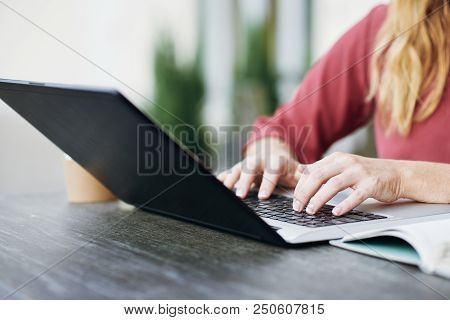 Close-up Of Female Hands Typing On Computer Keyboard At The Table Outdoors