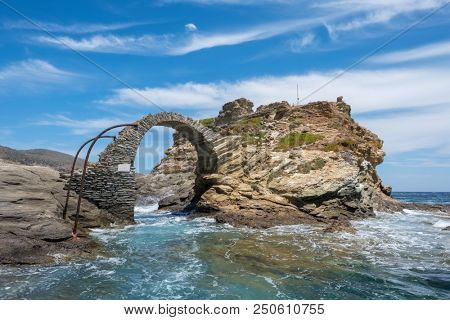 Old arched stone bridge in the beautiful town of Chora on Andros island, Cyclades, Greece
