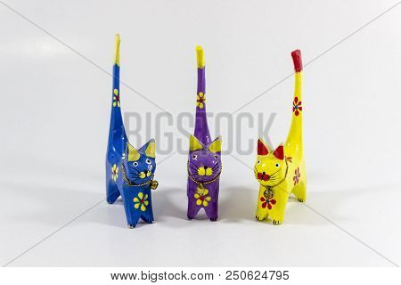 Front Close-up Shot Of Blue, Yellow And Purple Small Cat Figures Of Wooden Carved Nicknack