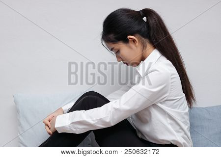 Anxious Stressed Young Asian Woman Sitting And Bend Down Head In Living Room.