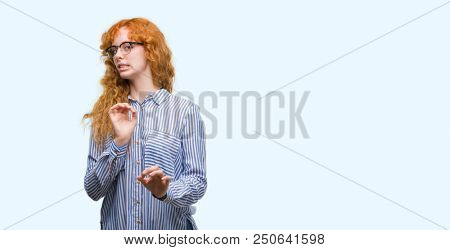 Young redhead bussines woman disgusted expression, displeased and fearful doing disgust face because aversion reaction. With hands raised. Annoying concept.