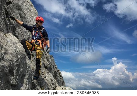 Young man climbing on a rock in Swiss Alps - via ferrata/klettersteig