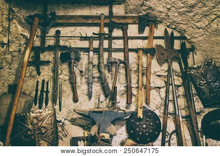 Wallpaper Background Of Ancient Medieval Weapons Hanged On A Vintage Stone And Concrete Wall. Histor