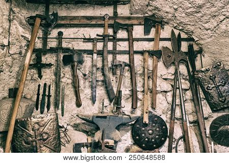 Wallpaper Background Of Ancient Medieval Weapons Hanged On A Vintage Stone And Concrete Wall. Histor
