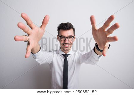 Portrait Of A Young Man With White Shirt And Necktie In A Studio, Hands In Foregorund.