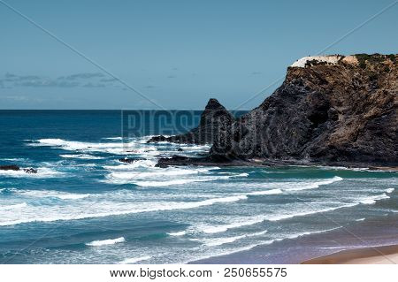 View On Praia De Odeceixe-mar With White Waves On Blue Sky Background Outdoors. Region Algarve, Port