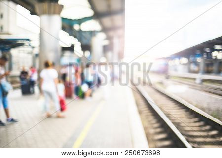 Blurred Image With Passengers Waiting Train On Platfom At Railway Station. Tourists With Baggage.