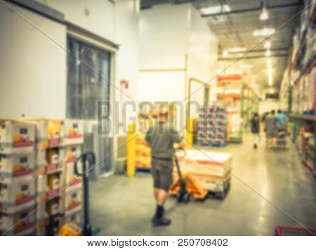 Worker With Manual Forklift Stockpile Goods Near Cold Storage Room In Wholesale Store