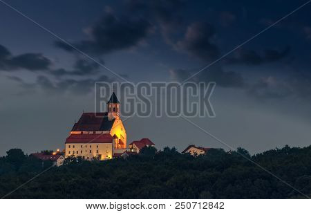 Illuminated Christian Church On Hill At Dusk, Ptujska Gora, Slovenia With Clouds And Fog In The Sky 