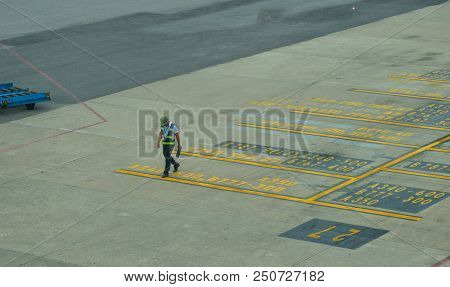 Da Nang, Vietnam - Jul 23, 2018. A Staff In Reflective Jacket Walking On The Runway Of Da Nang Inter