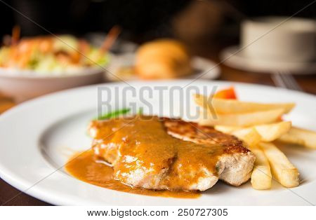 Pork Chop Steak With Dilicious Sauce And French Fries On The Pork In Lunch Time