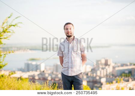 Portrait Of A Man In The Background Of Saratov, Russia, View Of The Houses, The Volga River, The Bri