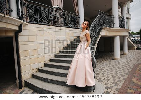 Elegant Lady Satnd On Stairs In Front Of Restaurant.