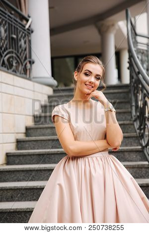 Elegant Lady Satnd On Stairs In Front Of Restaurant.