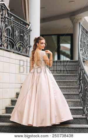Elegant Lady Satnd On Stairs In Front Of Restaurant.