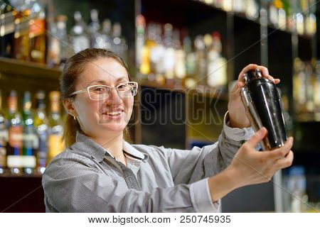 Professional Bartender Girl Holding In Hands A Shaker With A Fresh Delicious Cocktail. Barmaid Shaki