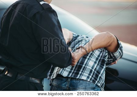 Police officer arrests the driver violator on road