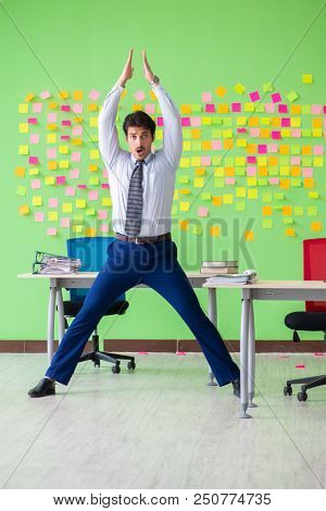Man in the office with many conflicting priorities doing exercis