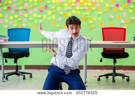 Man in the office with many conflicting priorities doing exercis