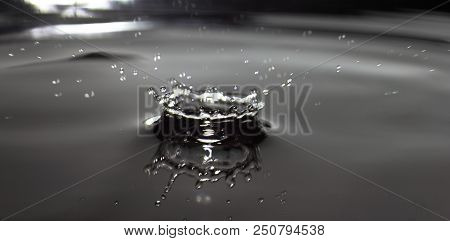 High Speet Photo Of A Water Drop Hitting The Surface Of Standing Water.