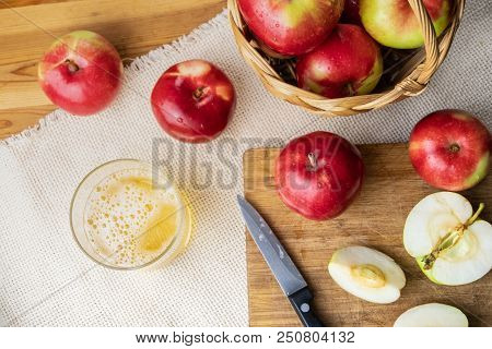 Top View Of Ripe Juicy Apples And Glass Of Cidre Drink On Rustic Wooden Table. Glass Of Home Made Ci