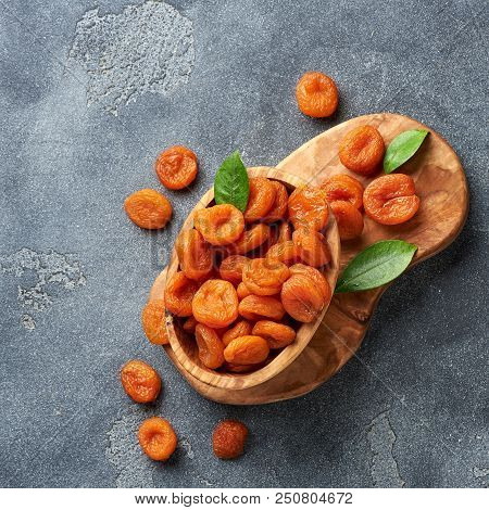 Dried Apricots With Green Leaves On Gray Background. Top View.