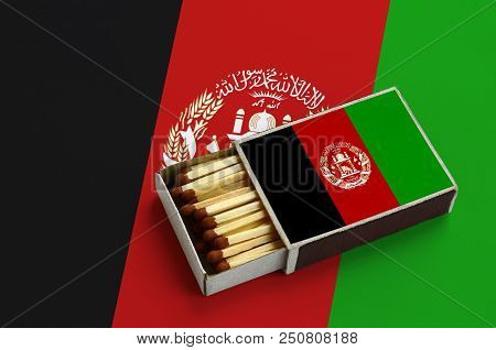 Afghanistan Flag Is Shown In An Open Matchbox, Which Is Filled With Matches And Lies On A Large Flag