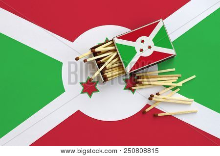 Burundi Flag  Is Shown On An Open Matchbox, From Which Several Matches Fall And Lies On A Large Flag