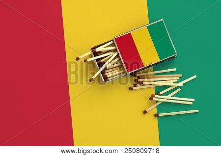 Guinea Flag  Is Shown On An Open Matchbox, From Which Several Matches Fall And Lies On A Large Flag.