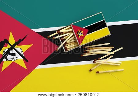Mozambique Flag  Is Shown On An Open Matchbox, From Which Several Matches Fall And Lies On A Large F
