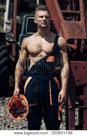 Metal Worker. Metal Worker Rest At Heavy Machinery. Handsome Metal Worker In Working Uniform. Strong