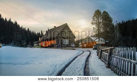 Wooden hut in winter forest at dusk. Rustic house for tourists in mountains in the night