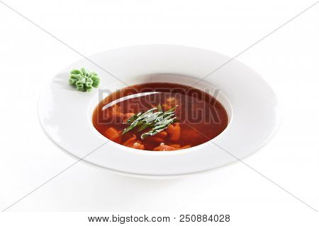 Hot Transparent Soup with Seafood in White Plate Isolated. Sour Spicy Bouillabaisse, Tom Yam, Miso or Halaszle with Red Fish Fillet, Green Onion and Wasabi