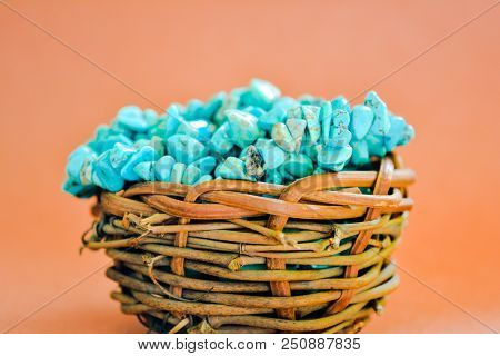 Pile Stones Of Raw Turquoise In Small Wooden Nest On A Brown Background. Blue And Green Color Stones