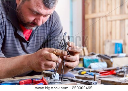 Sculptor Is Giving Stance, Attitude To His Figures Made Of Metal Wire In His Workshop.