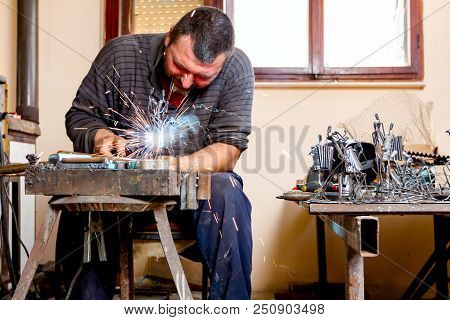 Sculptor Is Using Arc Welding To Assembly Metal Sculpture Without Proper Protection, Barehanded.