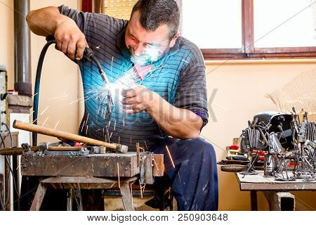 Sculptor Is Using Arc Welding To Assembly Metal Sculpture Without Proper Protection, Barehanded.
