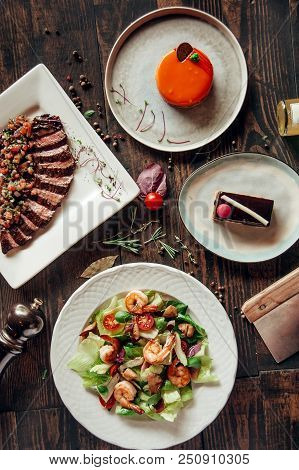 Menu Composition Of Dishes Decorated With Included Seafood Salad, Meat And Cake