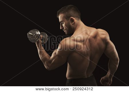 Athletic Young Man With Dumbbell On Black Background, Making Strenth Biceps Exercises. Naked Torso, 