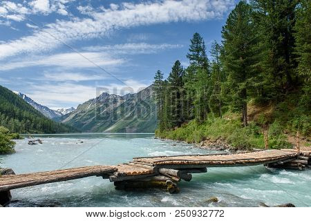 The Bridge Over The River Kucherla On The Shore Of The Kucherlin Lake In The Mountains, Altai.