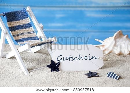 Summer Label With German Text Gutschein Means Voucher. Blue Wooden Background. Card With Holiday Gre