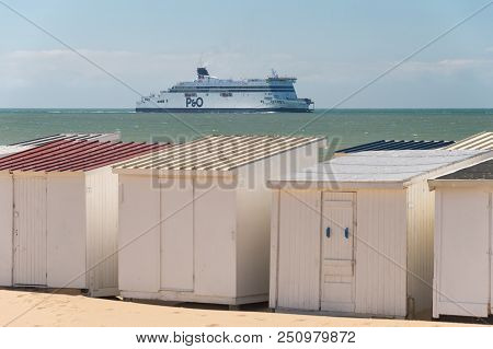 Calais, France - 19 June 2018: Beach Cabins And P&o Cross Channel Ferry On Its Way To The Port.