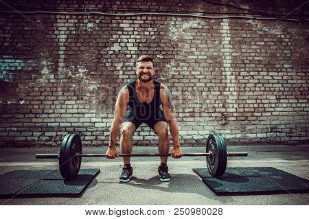 Muscular Fitness Man Doing Deadlift A Barbell Over His Head In Outdoor, Street Gym. Functional Train