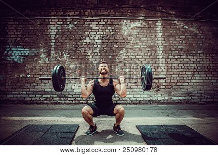 Muscular Fitness Man Doing Deadlift A Barbell Over His Head In Outdoor, Street Gym. Functional Train