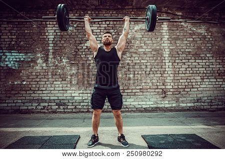 Muscular Fitness Man Doing Deadlift A Barbell Over His Head In Outdoor, Street Gym. Functional Train