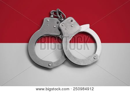 Indonesia Flag  And Police Handcuffs. The Concept Of Observance Of The Law In The Country And Protec