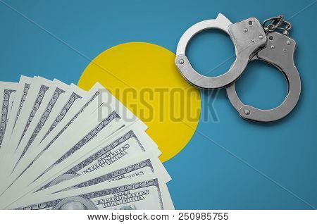 Palau Flag  With Handcuffs And A Bundle Of Dollars. The Concept Of Illegal Banking Operations In Us 