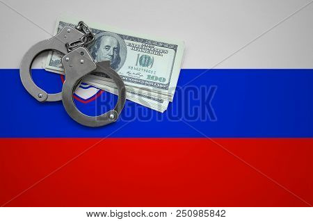 Slovenia Flag  With Handcuffs And A Bundle Of Dollars. The Concept Of Breaking The Law And Thieves C
