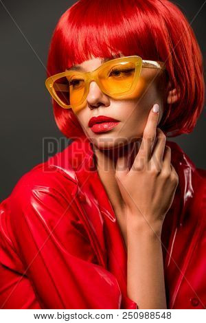 Close-up Portrait Of Fashionable Young Woman In Red Latex Jacket And Vintage Yellow Sunglasses Isola