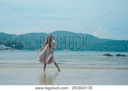 Handsome Girl On The Beach Background. Portrait Of A Woman In White Clothes On The Sea